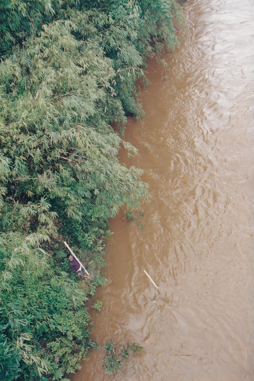Photograph of the flowing Bhadra river, looking extremely orange due to the sedimentation of iron ore.
